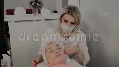 一位专业的美容师用特殊的保湿湿巾擦`女孩的脸。 美容学的新概念。